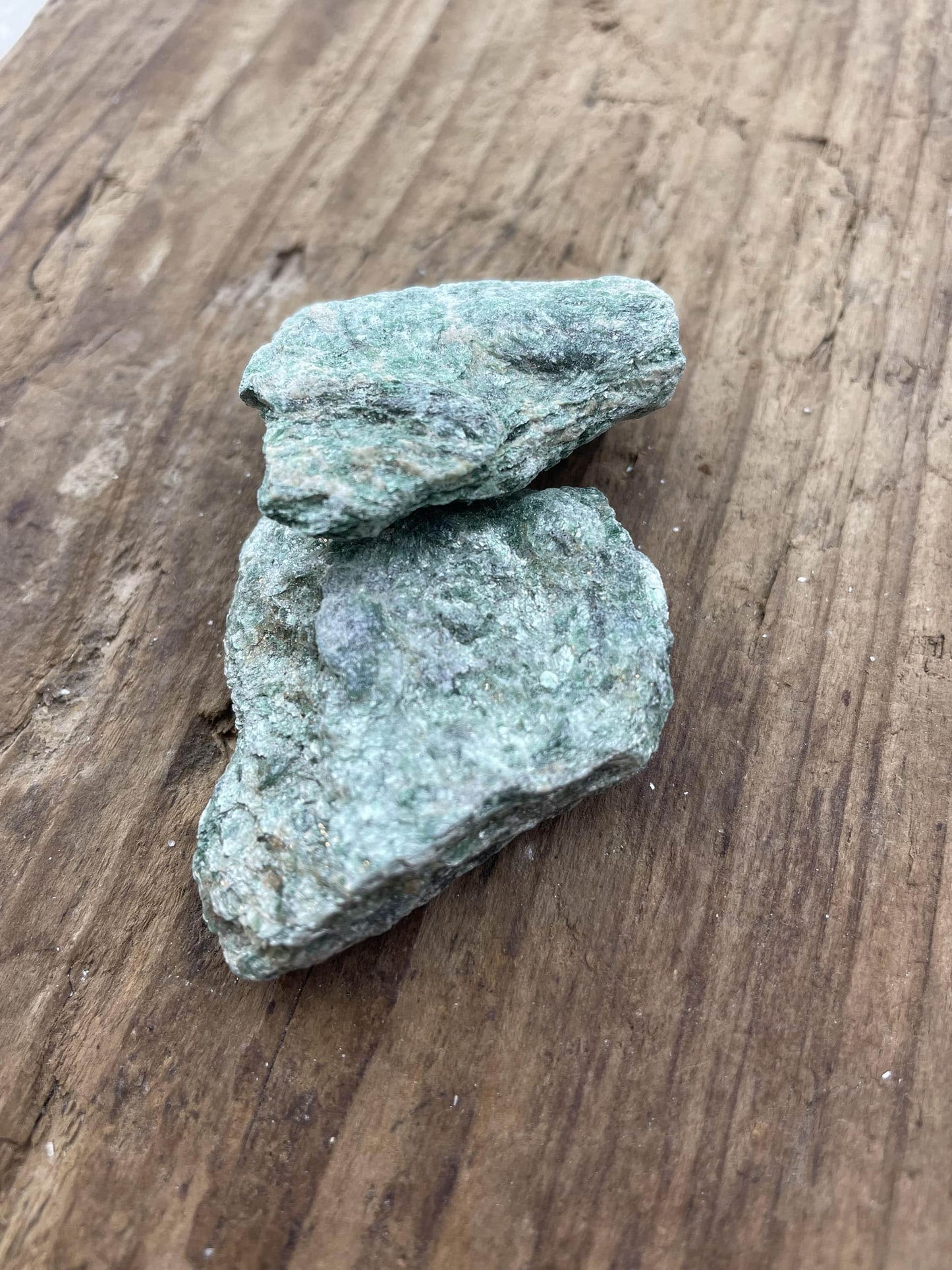 To stykker fuchsit på en træoverflade.