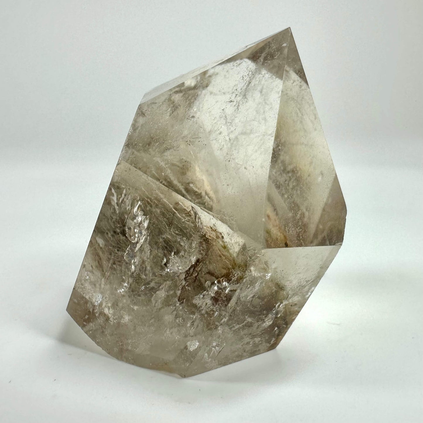 Fantomkvarts i fri form med klare og brune toner på hvid baggrund.