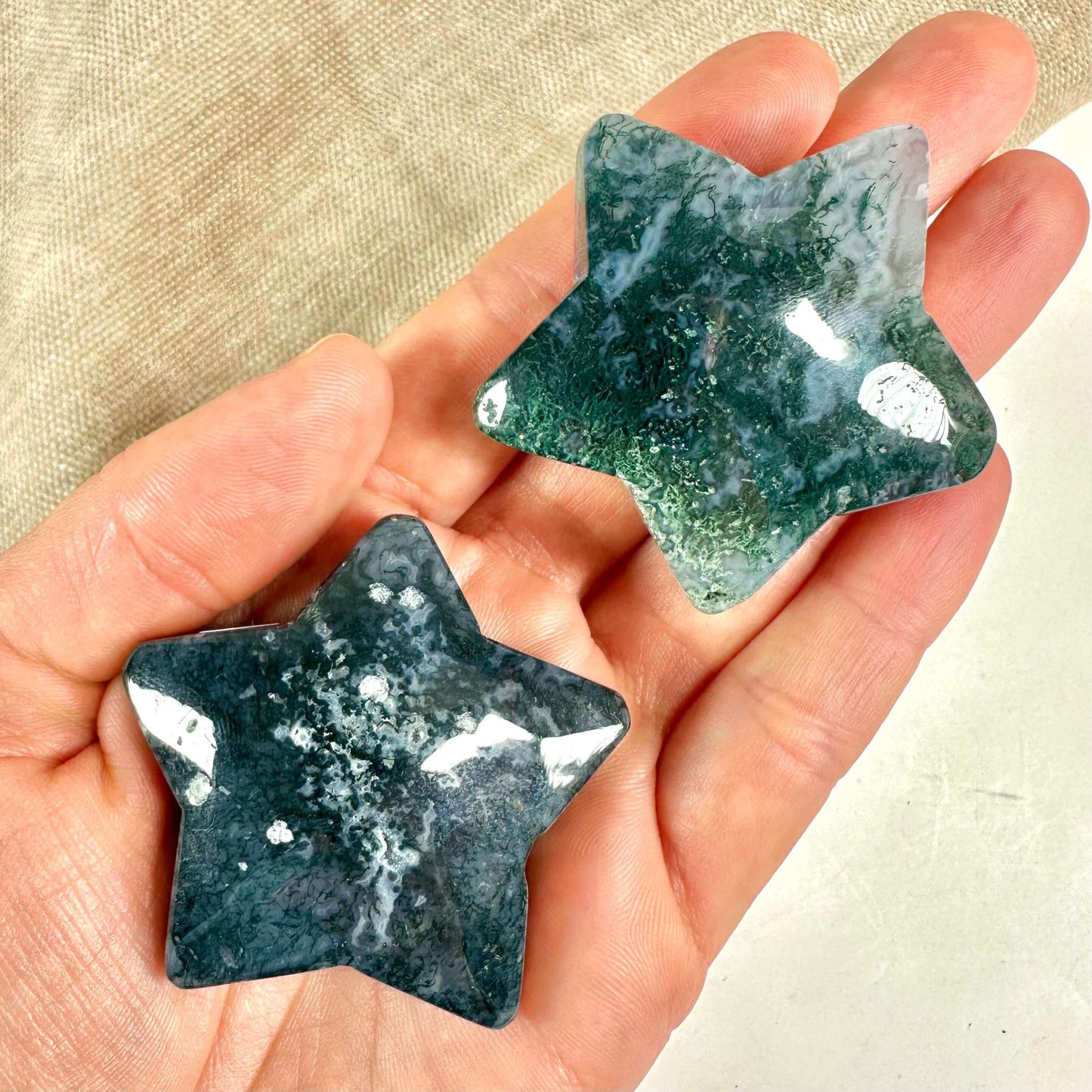 To mos agat stjerner holdes i en hånd, med deres grønne mønstre tydeligt synlige.