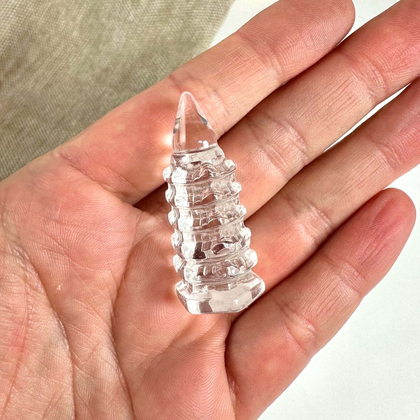 Hånd der holder en lille bjergkrystal tempelfigur.