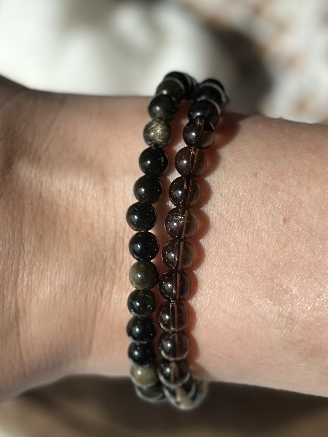 To armbånd med perler omkring et håndled, teksten "Styrk dit selvværd" kunne relatere til armbåndenes beroligende effekt.