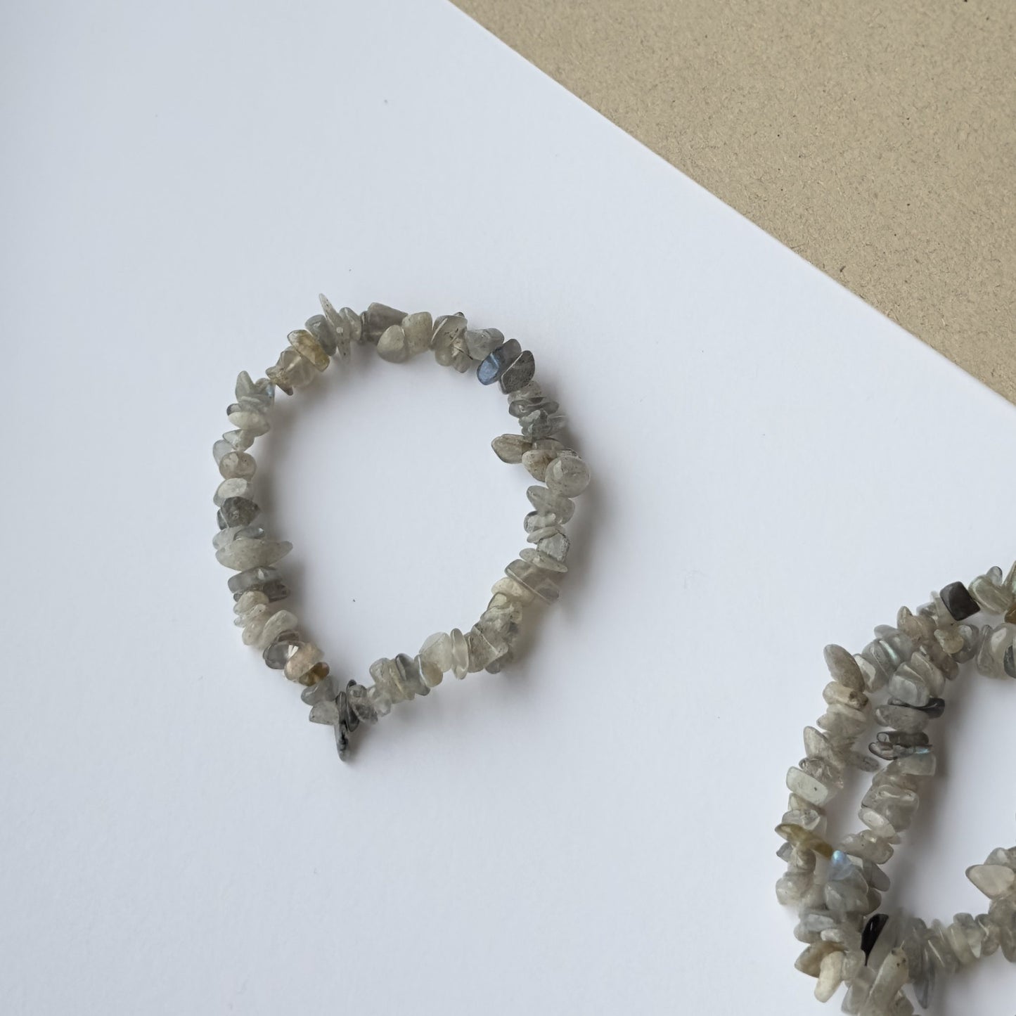 Labradorit armbånd med små sten på en lys baggrund.