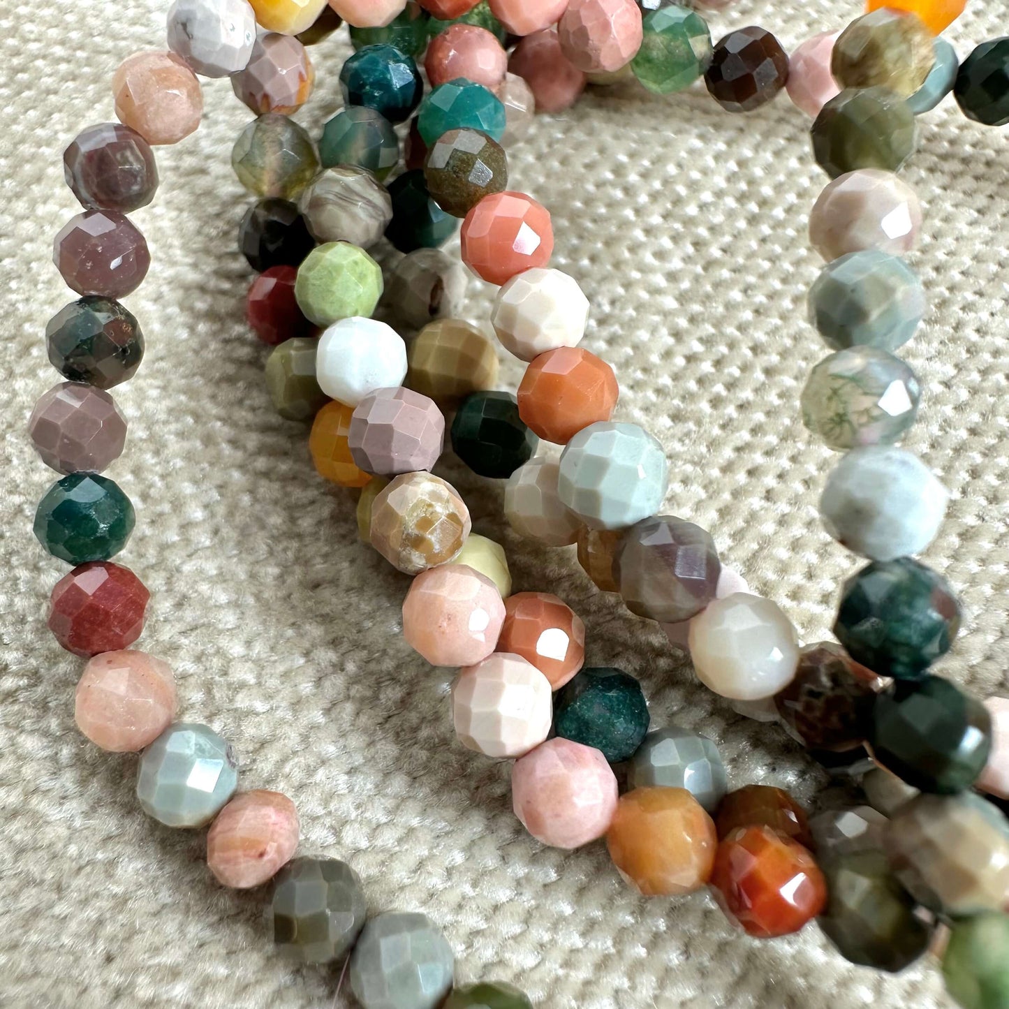 Farverige facetterede perler på en neutral baggrund.