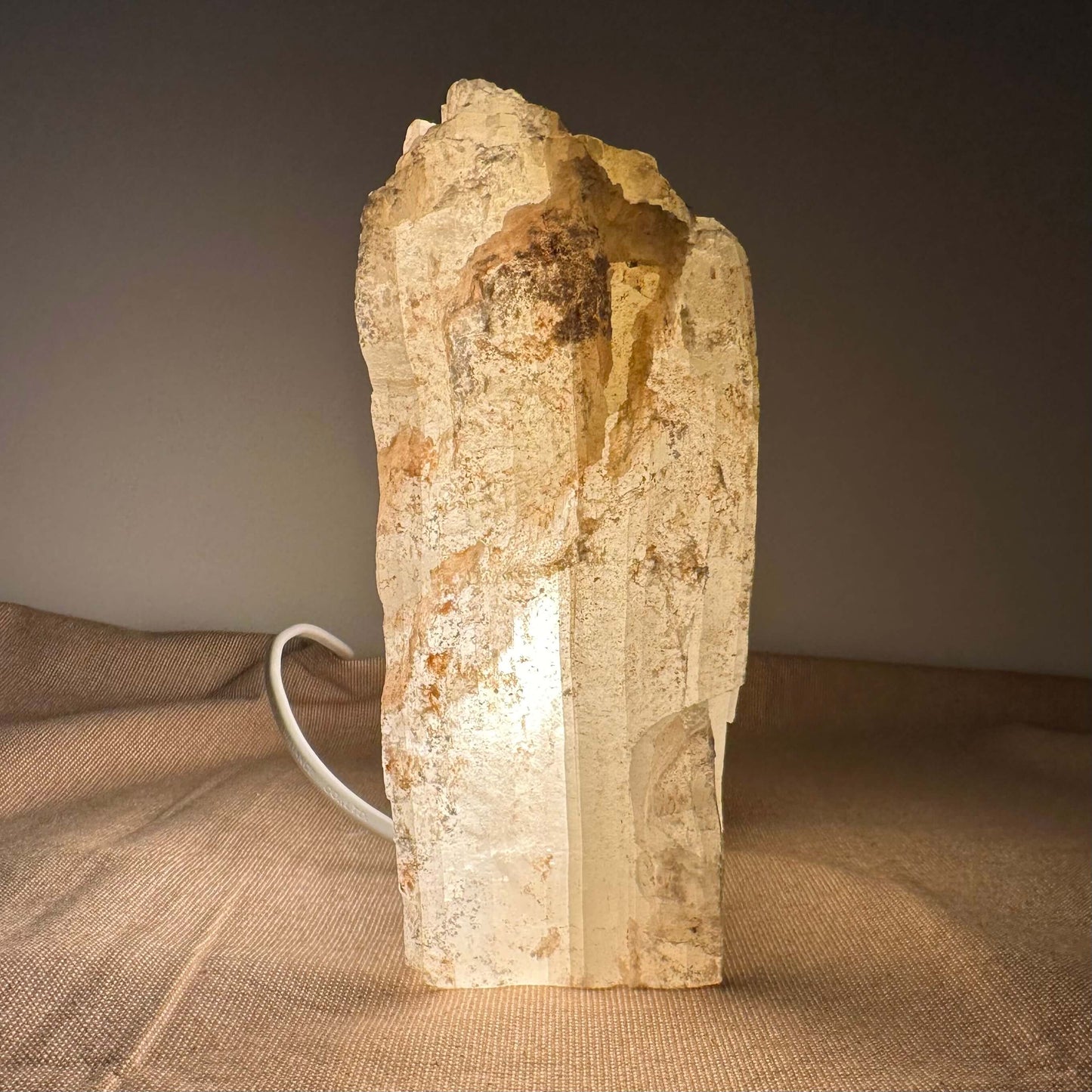 En kop lavet af en stenblok med et håndtag bagved, placeret på en brun klud.