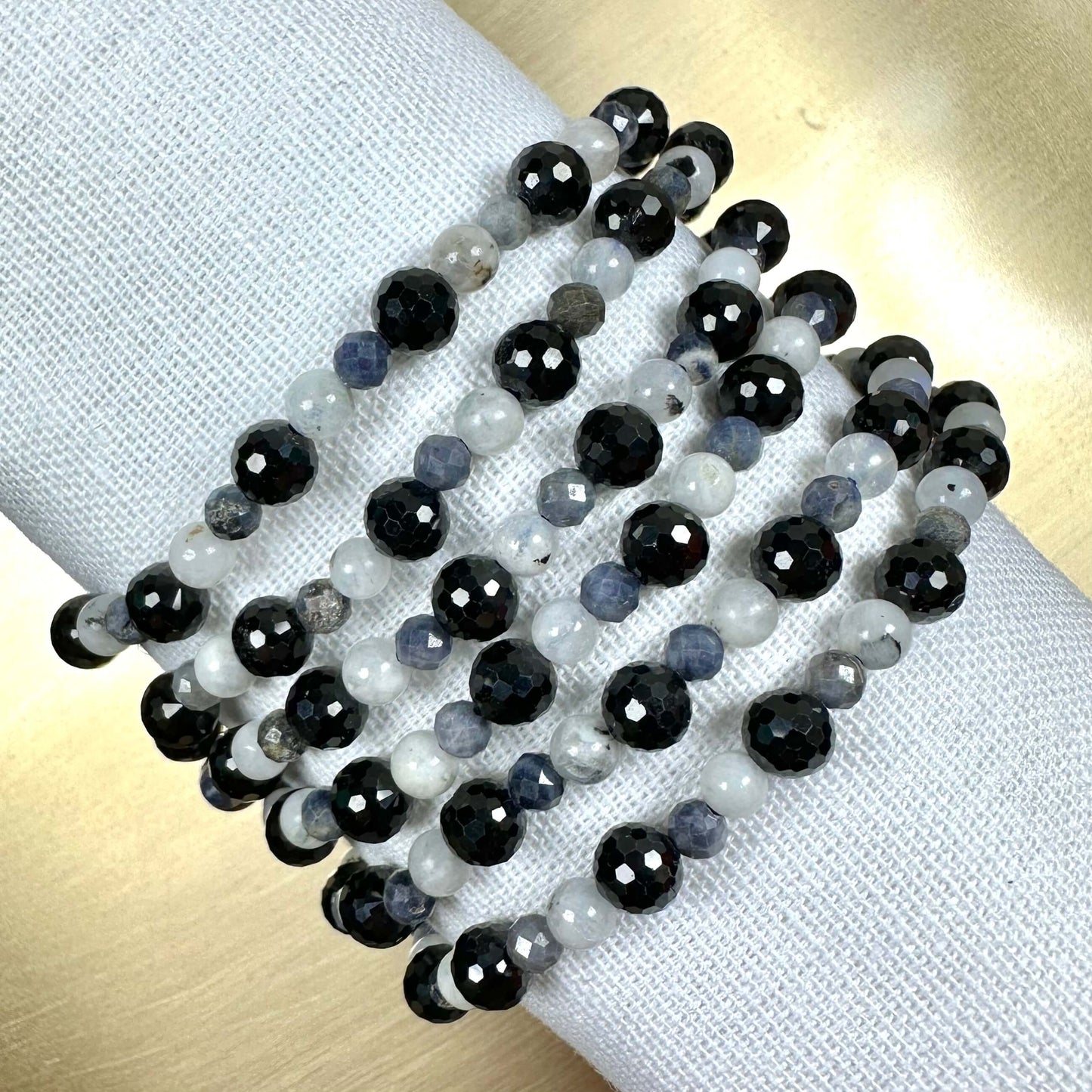 Sorte og hvide perlehalskæder viklet om en stofklud.