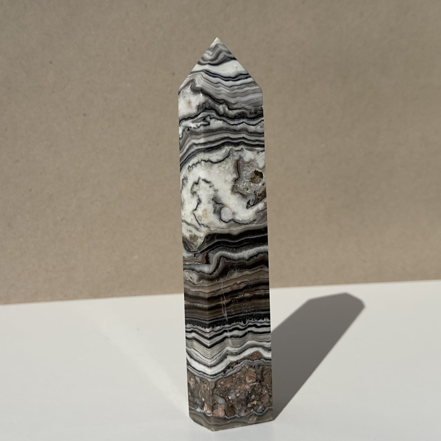 Zebra Calcit tårn med sort og hvidt mønster, placeret på en lys overflade.