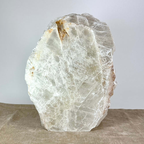 Et stort, transparent krystal på brunt stof, belyst mod en lys baggrund.