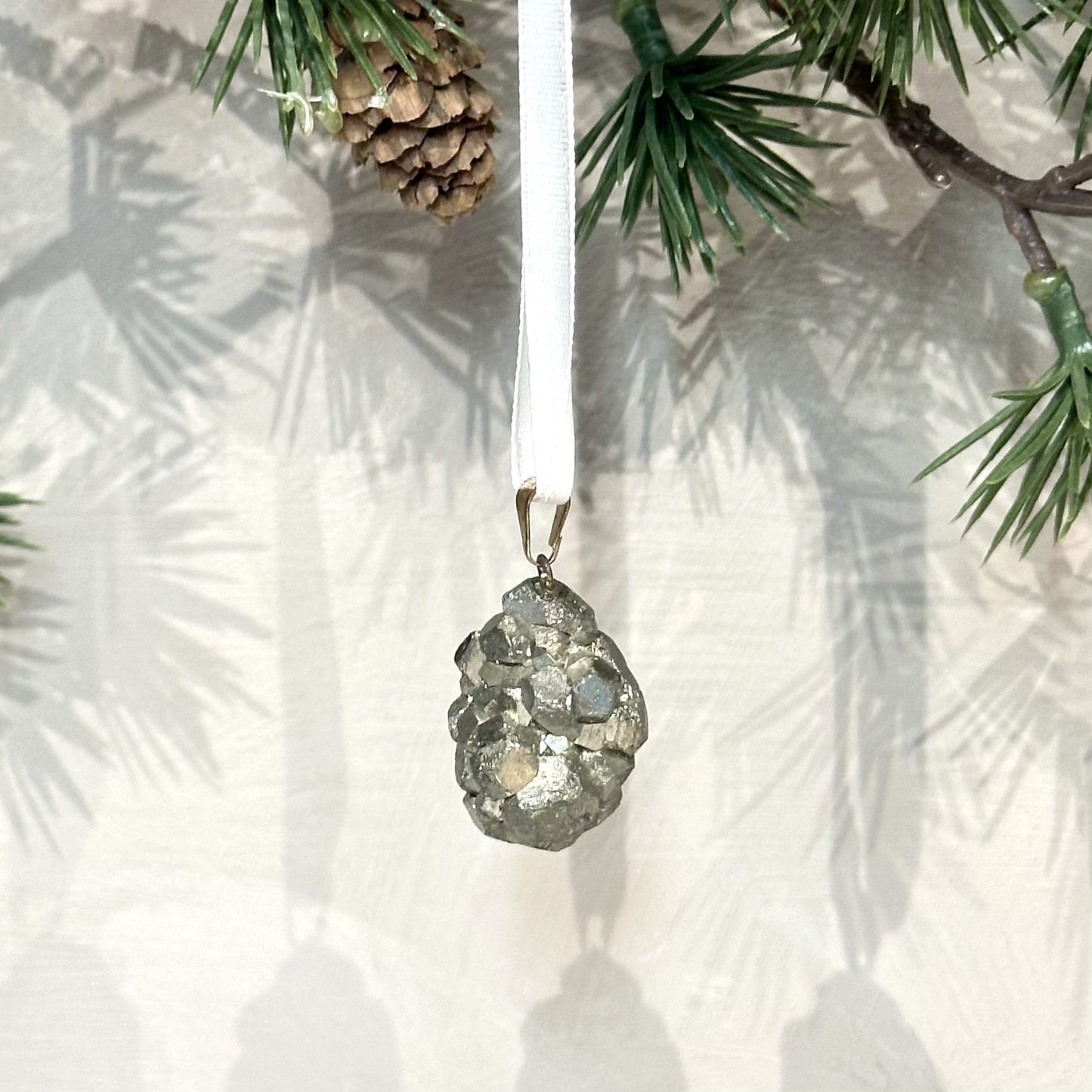Pyrit ophæng i juletræsgrene med en hvid snor.