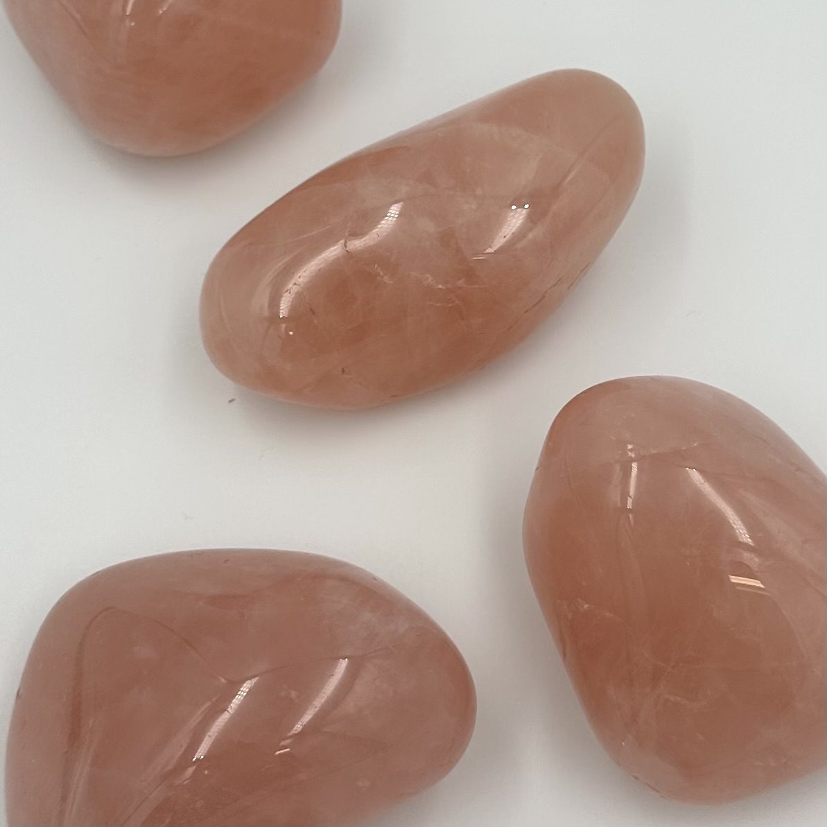 Rosenkvarts jumbo sten i bløde lyserøde nuancer på en hvid baggrund.