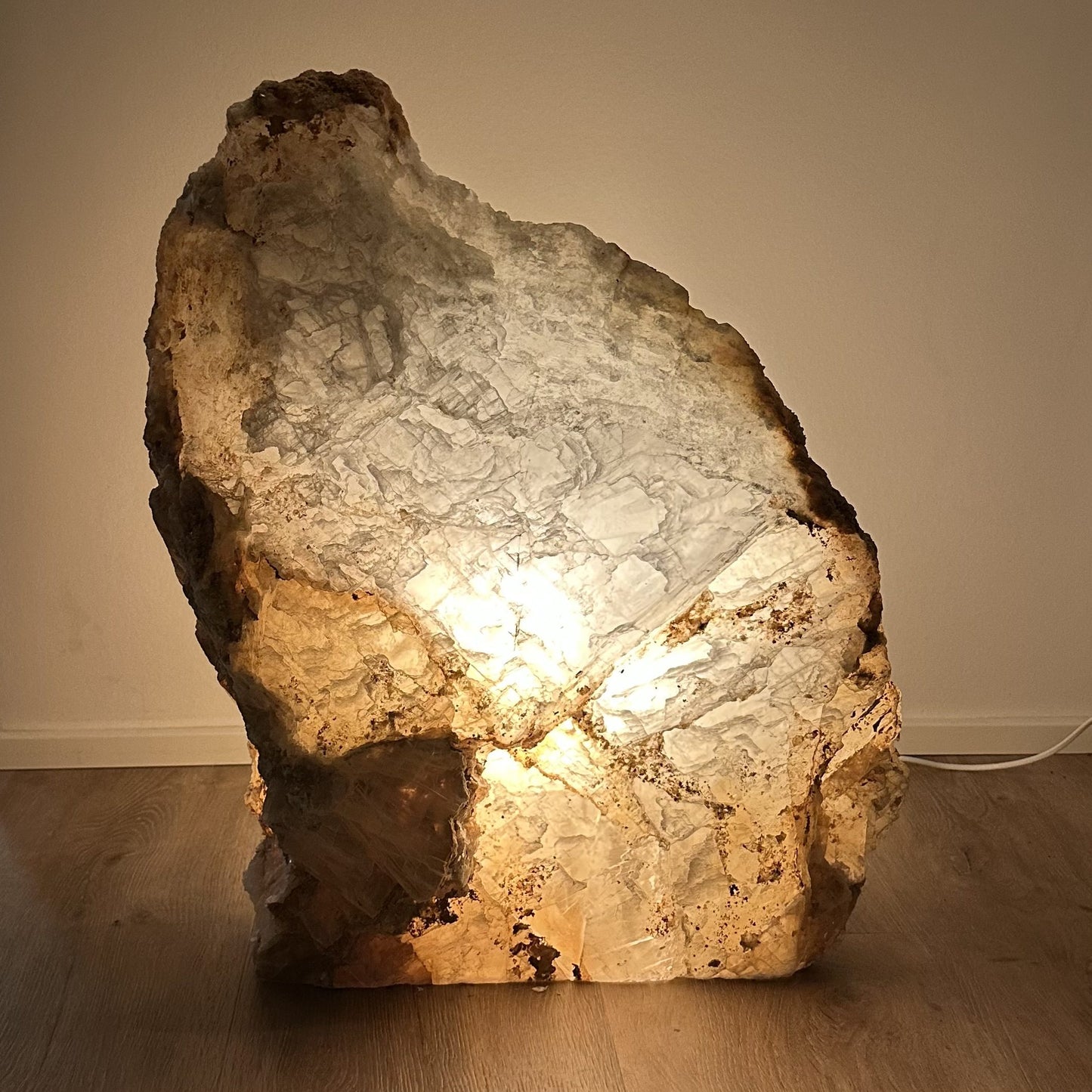 Naturstenlampe udstråler varm glød, skaber æstetisk ro i rummet, del af FÈ Luminous Serenity Collection.