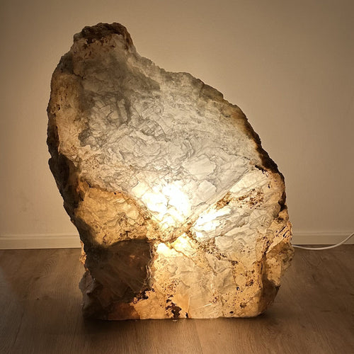 Naturstenlampe udstråler varm glød, skaber æstetisk ro i rummet, del af FÈ Luminous Serenity Collection.