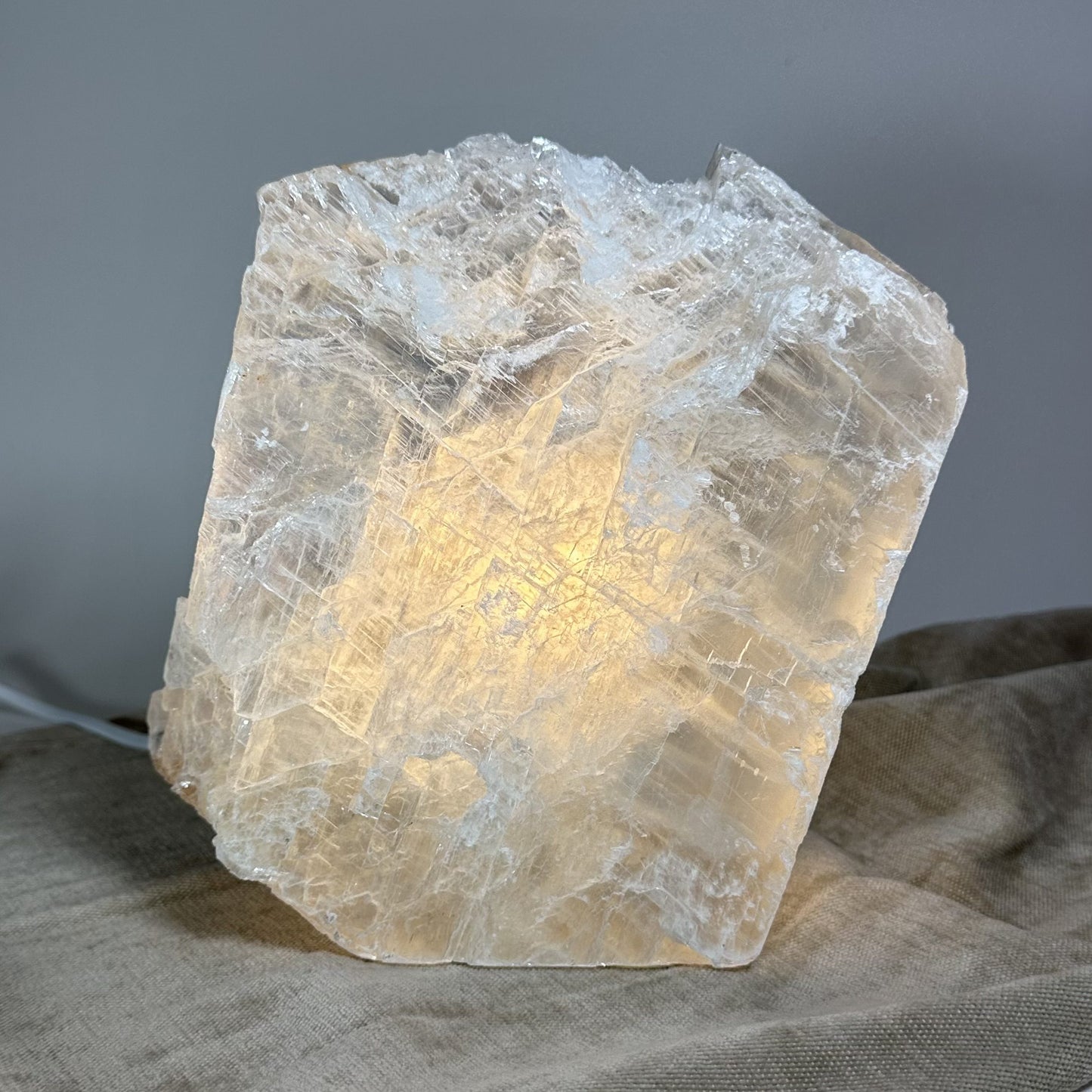 Mexicansk Selenit lampe nr 43 med let lysende stenstruktur på en beige overflade.