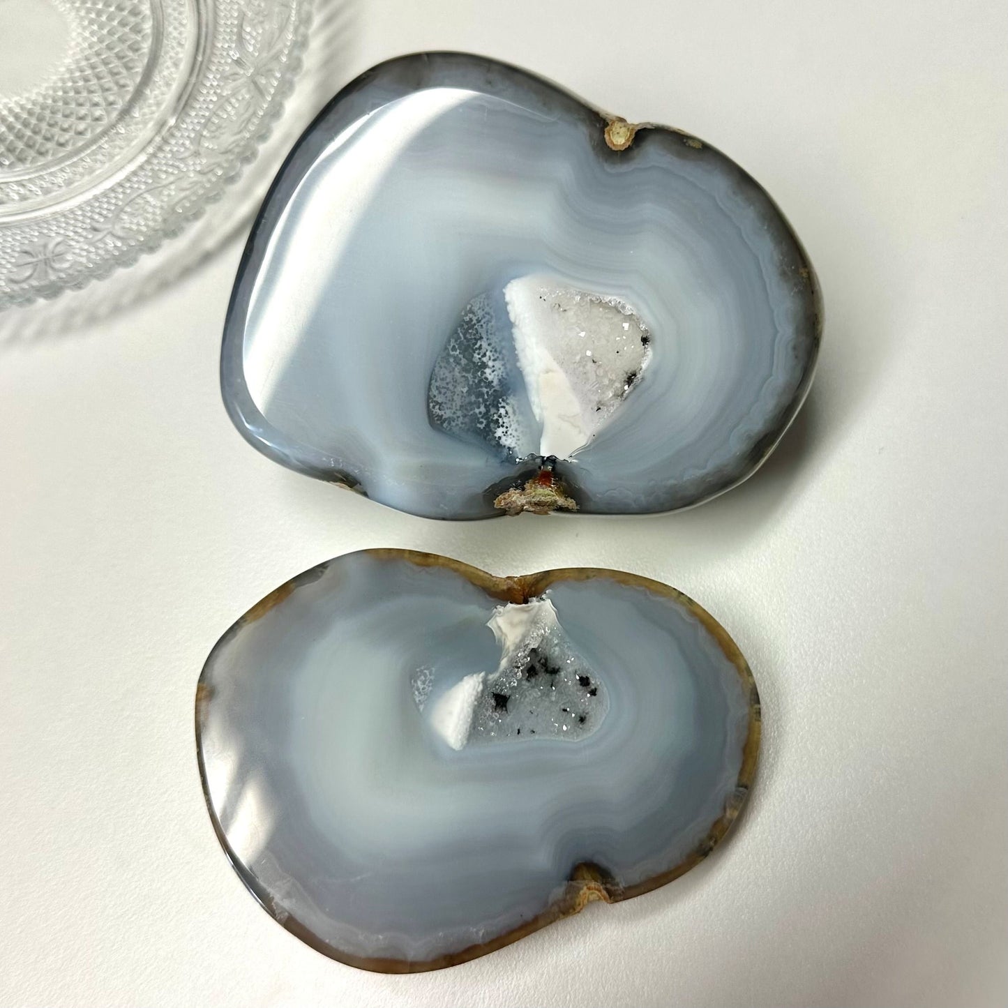 Agat natur geode sæt med to halve, blålige skiver med krystalstruktur på hvid baggrund.