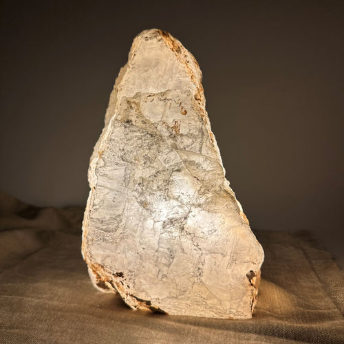 Mexicansk Selenit lampe nr 54 gløder blødt på en mørk baggrund, med lyse og rustikke overflade detaljer.