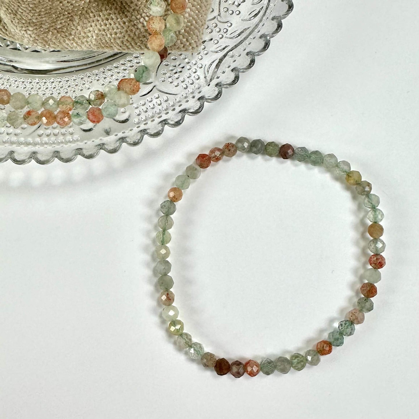 Arusha solsten armbånd i forskellige nuancer på en glasbakke og hvid baggrund.