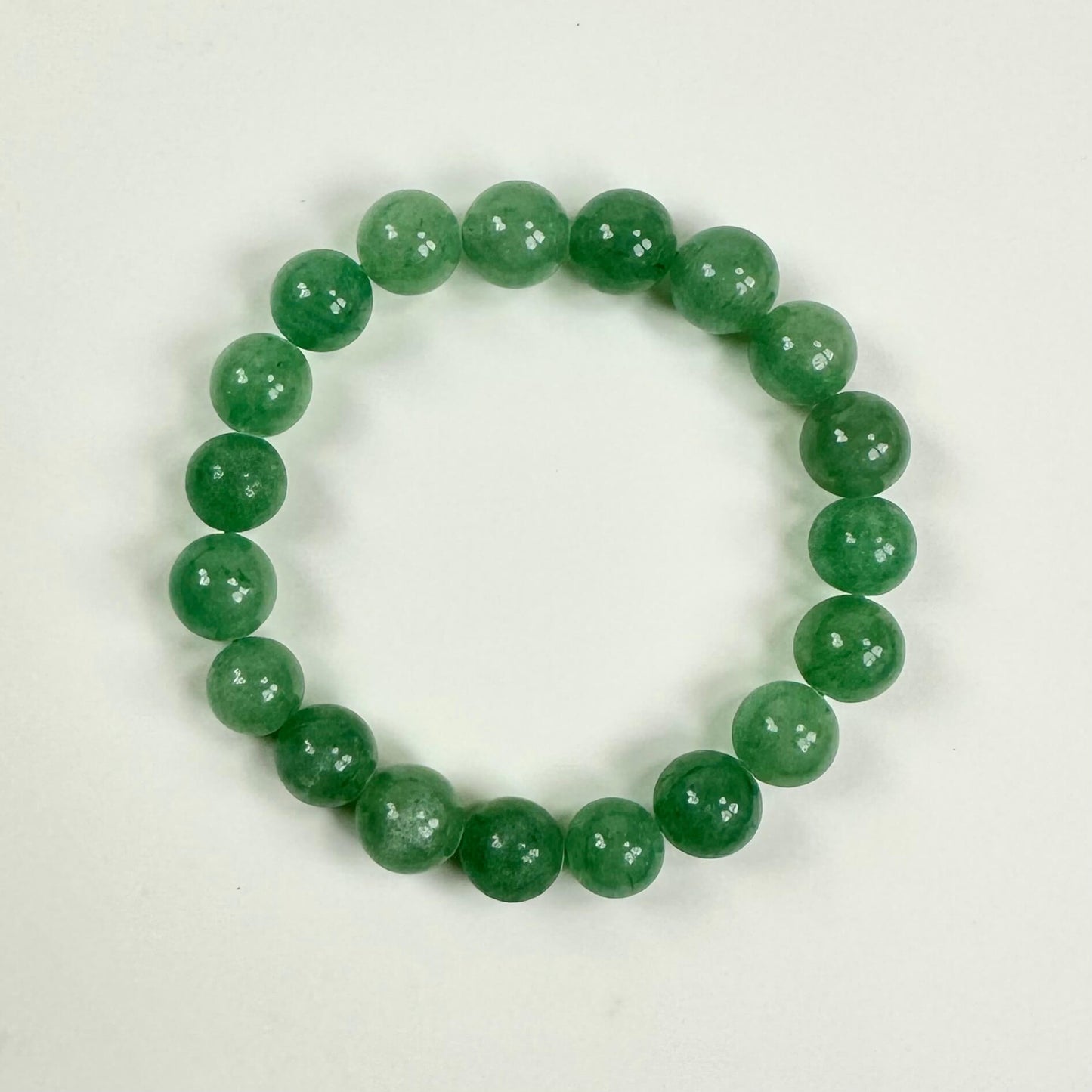 Grøn aventurin armbånd med runde perler i en cirkel på hvid baggrund.