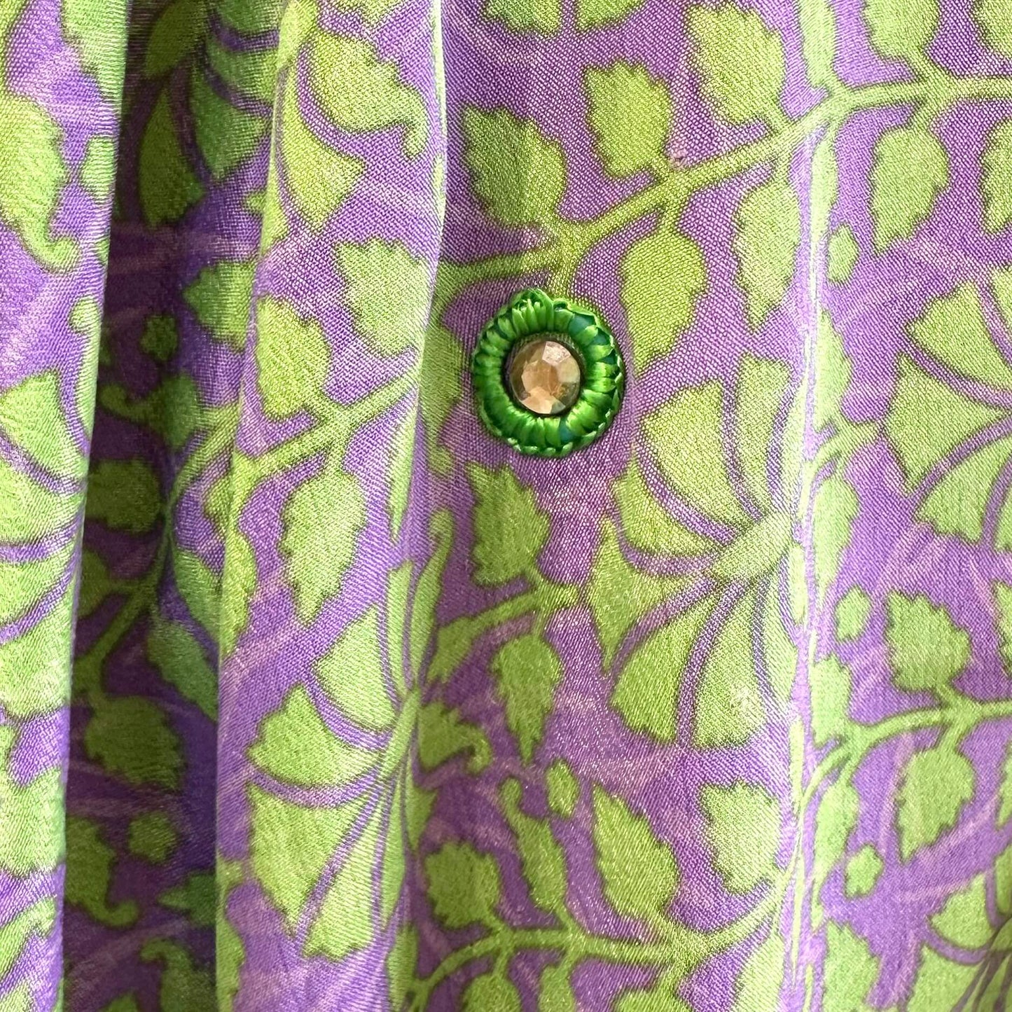 Dekorativt mønster på lilla og grøn kimono med rund knap.