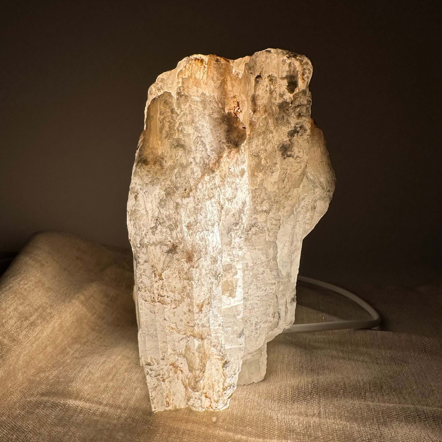 Mexicansk Selenit lampe nr 40 i en oplyst stenformat på en lys dug, set mod en mørk baggrund.