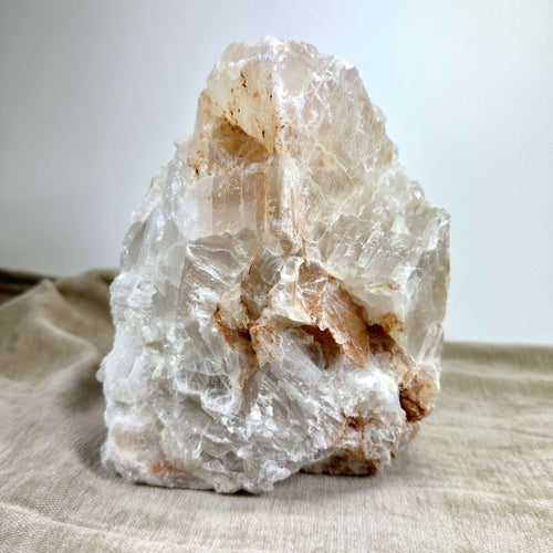 Mexicansk Selenit lampe nr 34 med naturlige nuancer af hvid og beige, placeret på en lys klud.