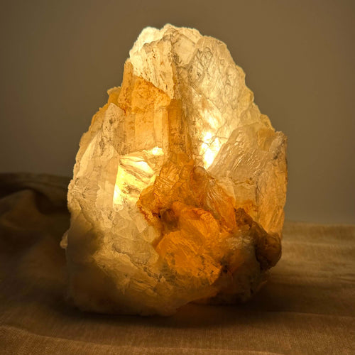 Mexicansk Selenit lampe nr 34 udsender et varmt, gyldent lys, placeret på en blød overflade i dæmpet belysning.