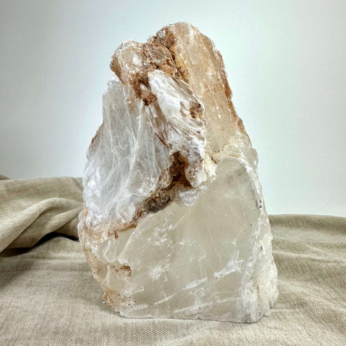 Mexicansk Selenit lampe nr 6, naturlig stenstruktur på beige stofbaggrund.
