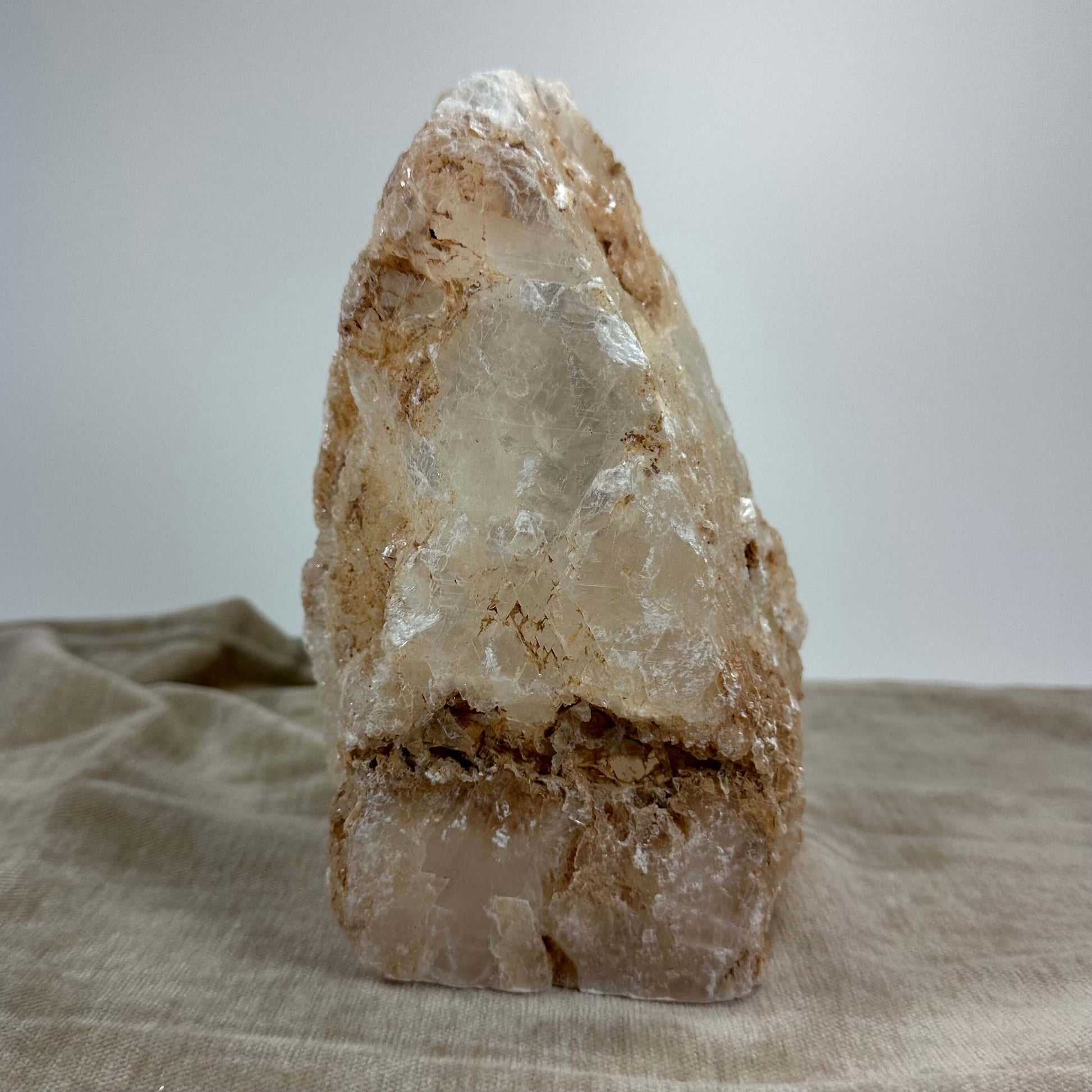 Mexicansk Selenit lampe nr 44 med rå, uregelmæssig overflade på lys baggrund. Placering på stof.