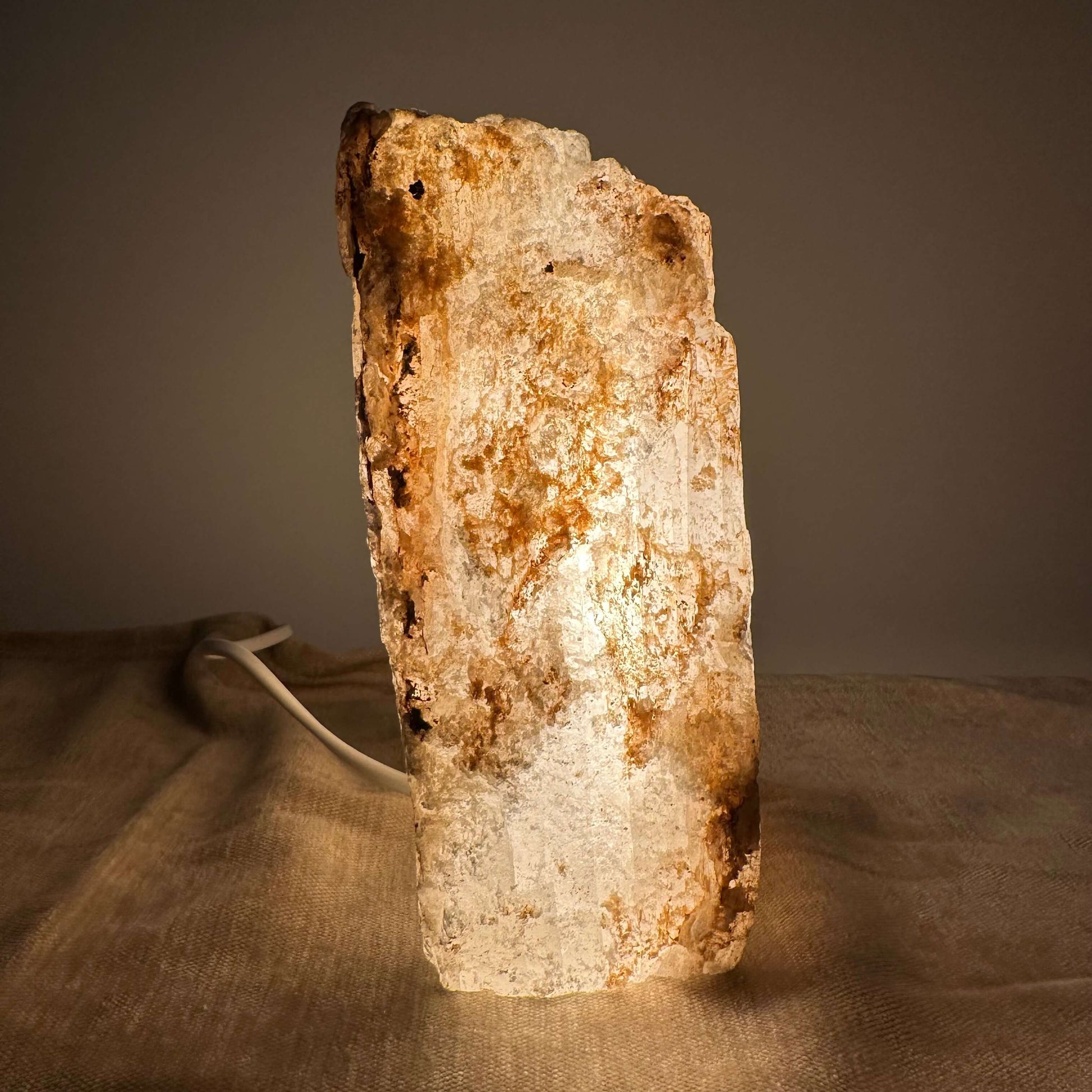 Mexicansk Selenit lampe nr 44 lyser blødt op på en mørk baggrund med sin rustikke tekstur.