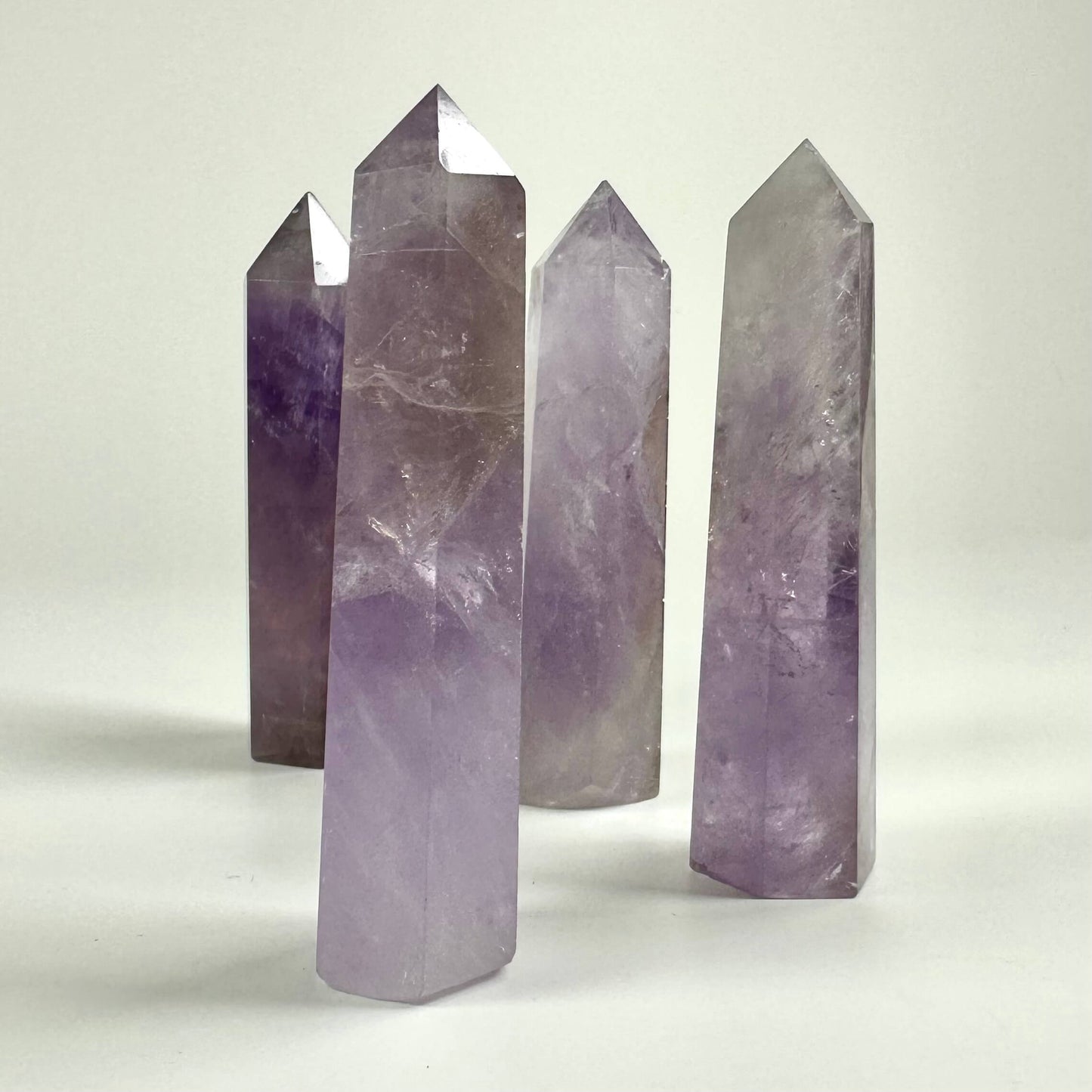 Fem ametyst tårne står oprejst med lys baggrund.