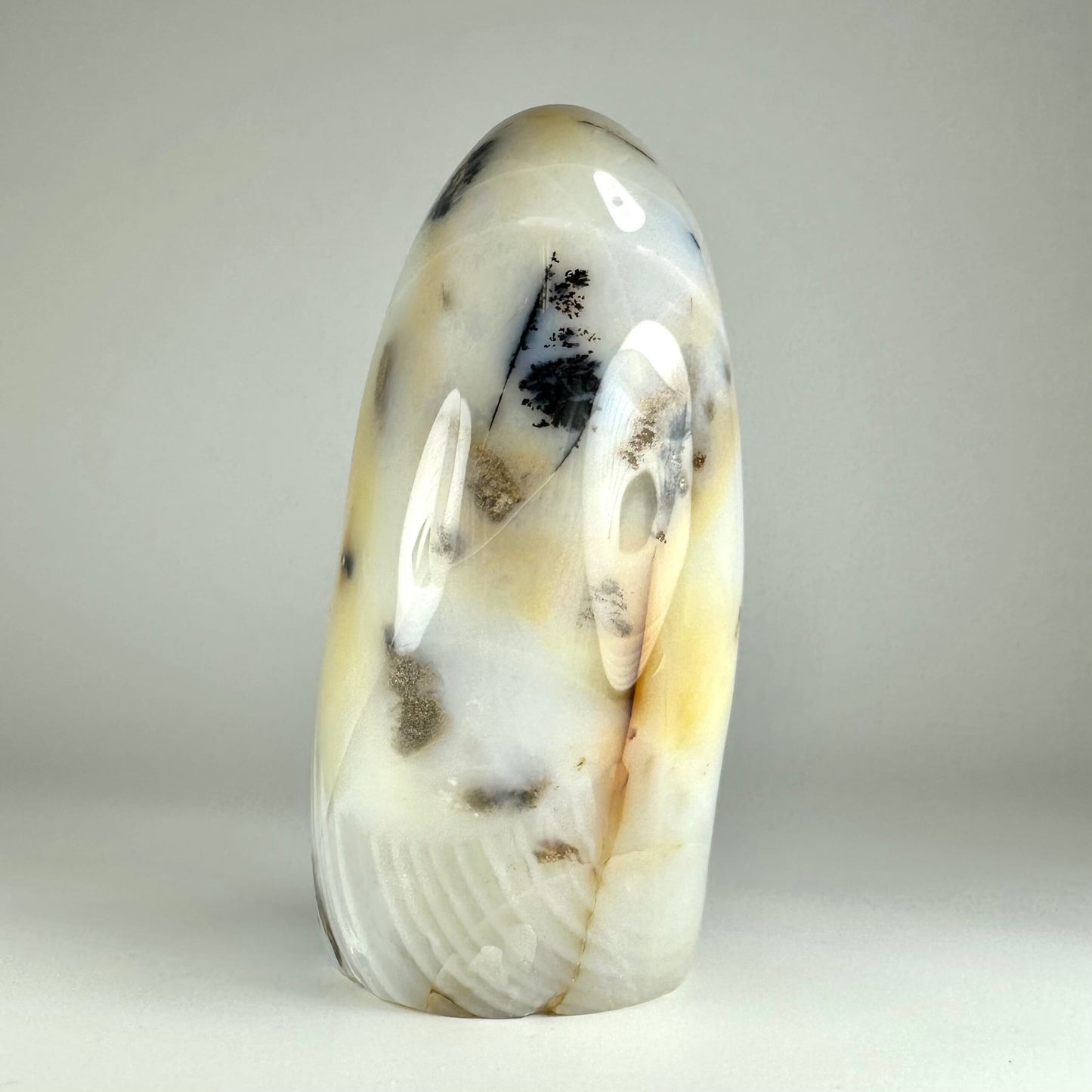 Agat dendrit free form med mælkehvid baggrund og sorte mønstre, der ligner træer, præget af naturlige jordfarver.