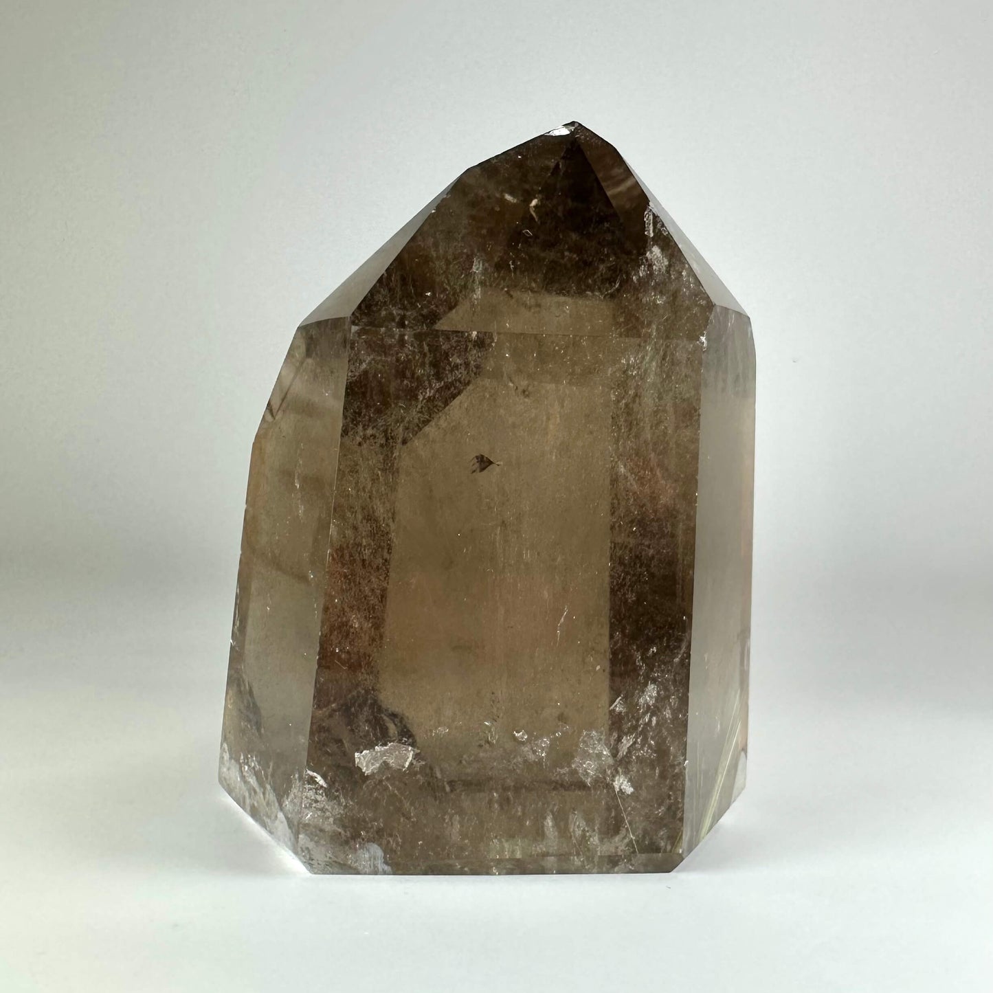 Røgkvarts tårn med en klar, brunlig nuance mod en neutral baggrund.
