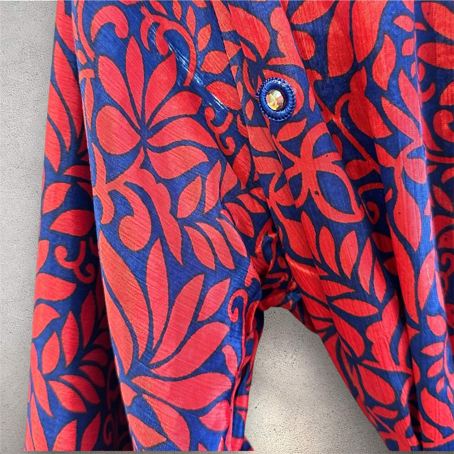 Rød og blå kimono med bladmønster og en knapdetalje.