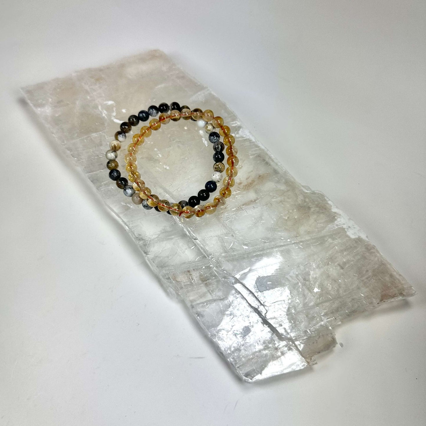 Armbånd med farverige perler placeret på en Mexicansk selenit plade rå.