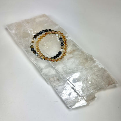 Armbånd med farverige perler placeret på en Mexicansk selenit plade rå.