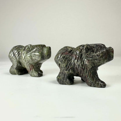 To statuer af bjørne skåret i Drageblod, placeret på en hvid baggrund.