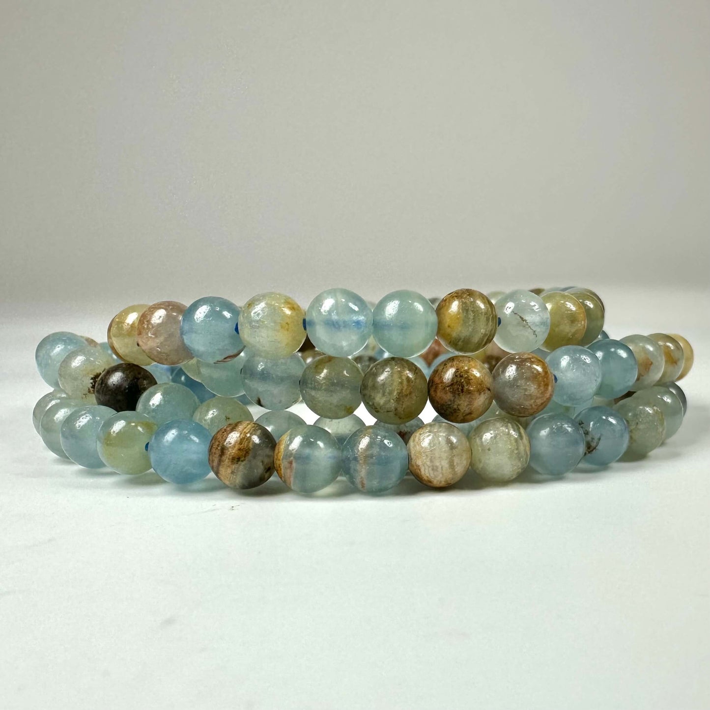 Armbånd med blå og beige sten: Akvatin lemurie calcit armbånd 6mm i flere lag.
