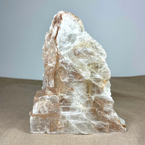 Et stort stykke af hvid og brun bjergkrystal på en neutral baggrund.