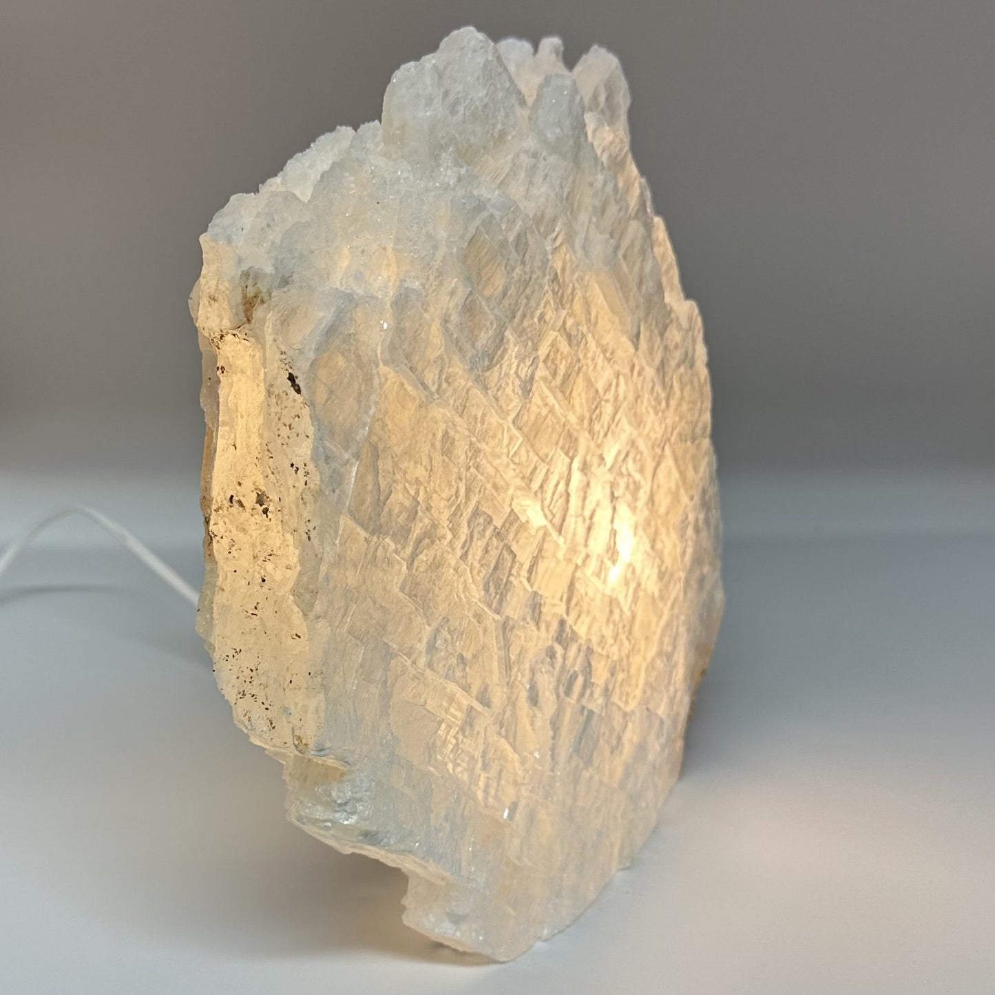 Mexicansk Selenit lampe nr 20 set tændt, viser sin naturlige, krystallinske struktur med en varm glød.