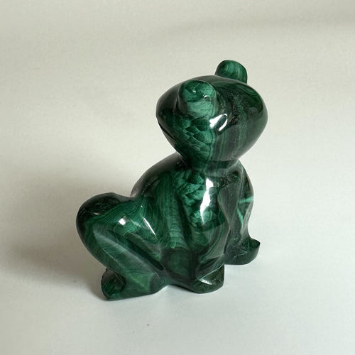 Malakit frø skulptur med glat, poleret overflade og mørkegrønne nuancer mod en lys baggrund.