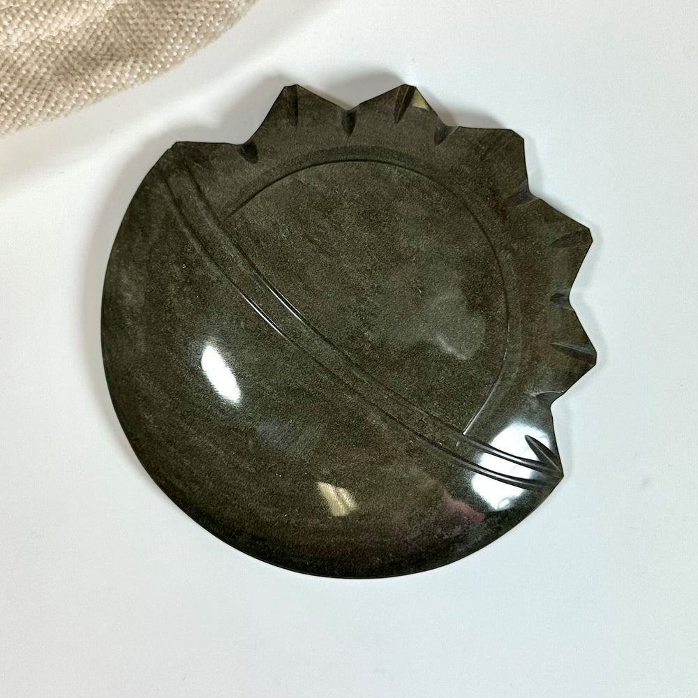Guld Obsidian sol og måne skulptur med poleret overflade på hvid baggrund.