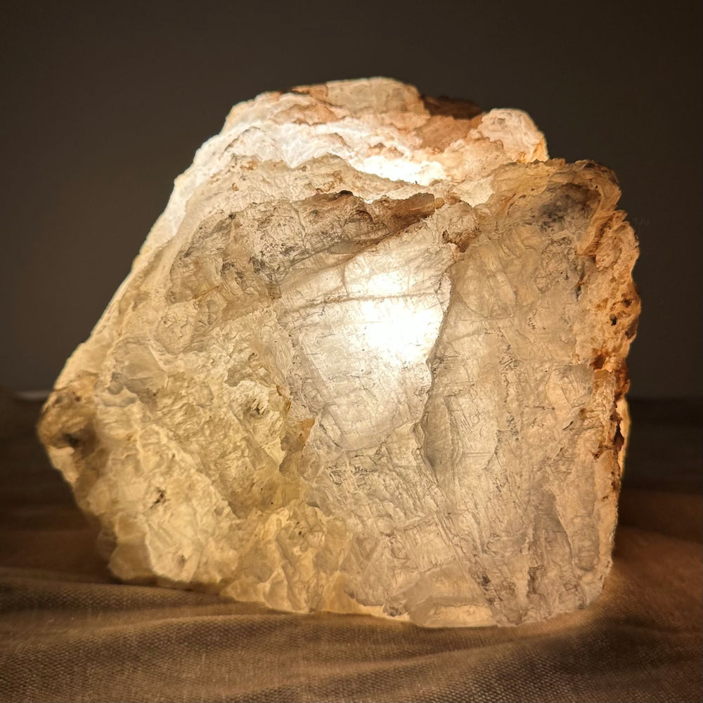Mexicansk Selenit lampe nr 56, der udstråler et varmt, blødt lys, placeret på en stofoverflade.