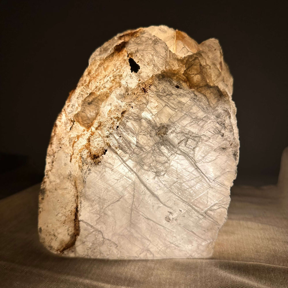 Mexicansk Selenit lampe nr 40 med naturlige årer og strukturer, oplyst med en varm glød i mørket.