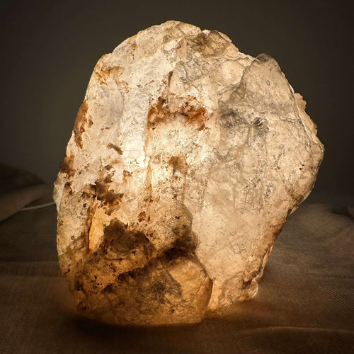 Mexicansk Selenit lampe nr 9 lyser op i en varm glød med naturlige teksturer i en dæmpet, dunkel atmosfære.