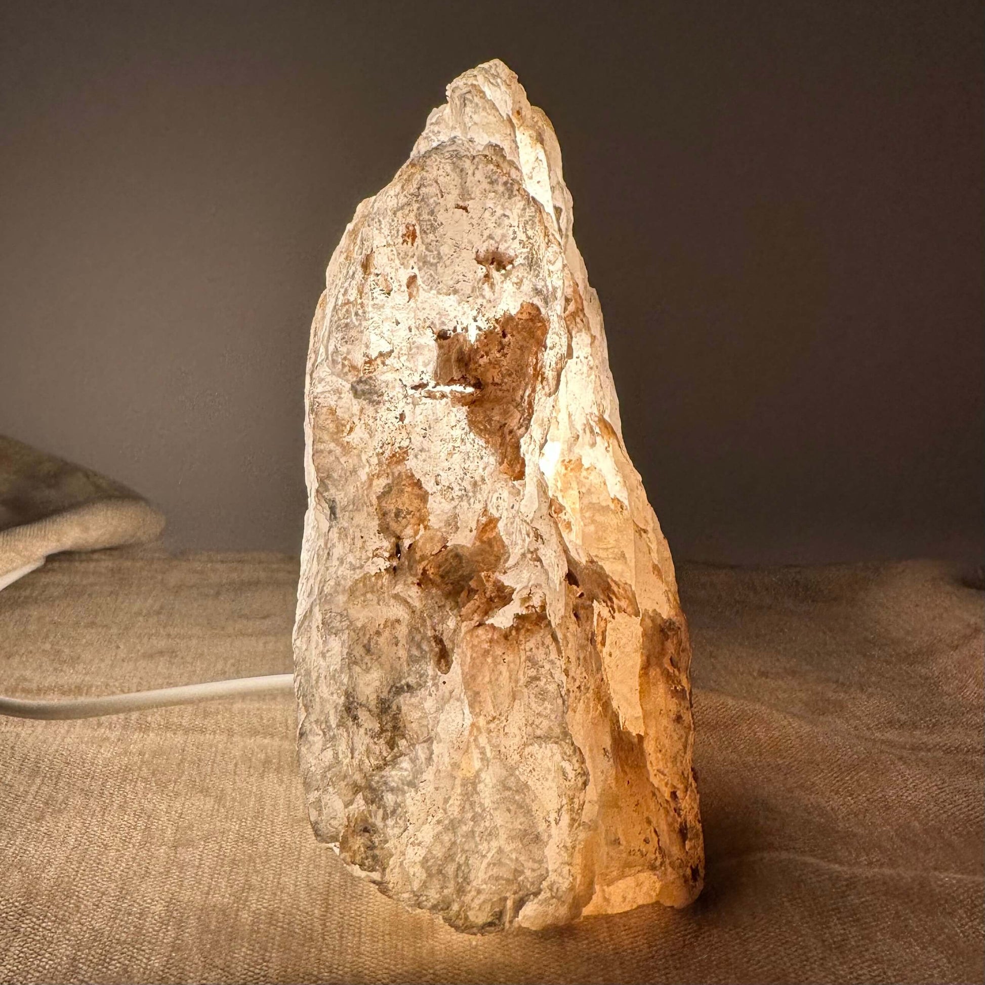 Mexicansk Selenit lampe nr 9 lyser op på en bordflade med en varm, naturlig glød og fremhæver stenens tekstur.
