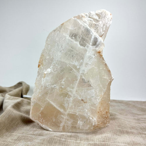 Mexicansk Selenit lampe nr 50 i natursten-look på en beige tekstilbaggrund.