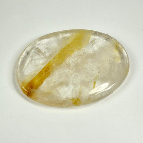 Oval, gennemsigtig Golden Healer skive med gule striber på en hvid baggrund.